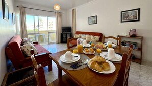 Ein Essbereich mit einem Tisch, der für das Frühstück gedeckt ist, einschließlich Croissants, Saft und einer weißen Tasse.