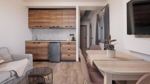Una cucina moderna con mobili in legno, un forno integrato e un'area pranzo con tavolo e sedie.