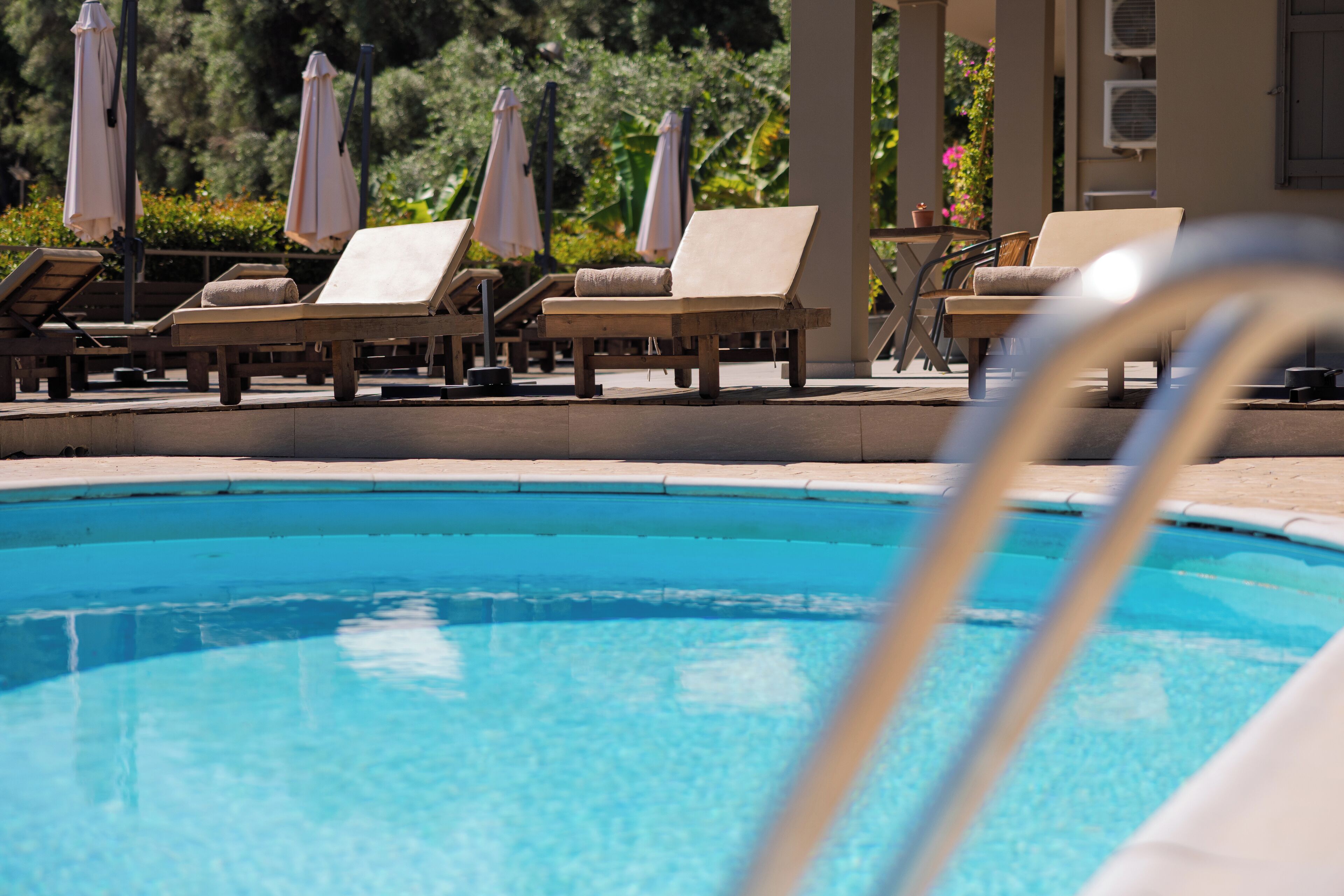 Un espace piscine équipé de chaises longues et de parasols.