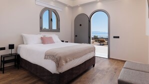 Una camera da letto con un letto grande, un comodino, una finestra e una porta che dà su una zona esterna.