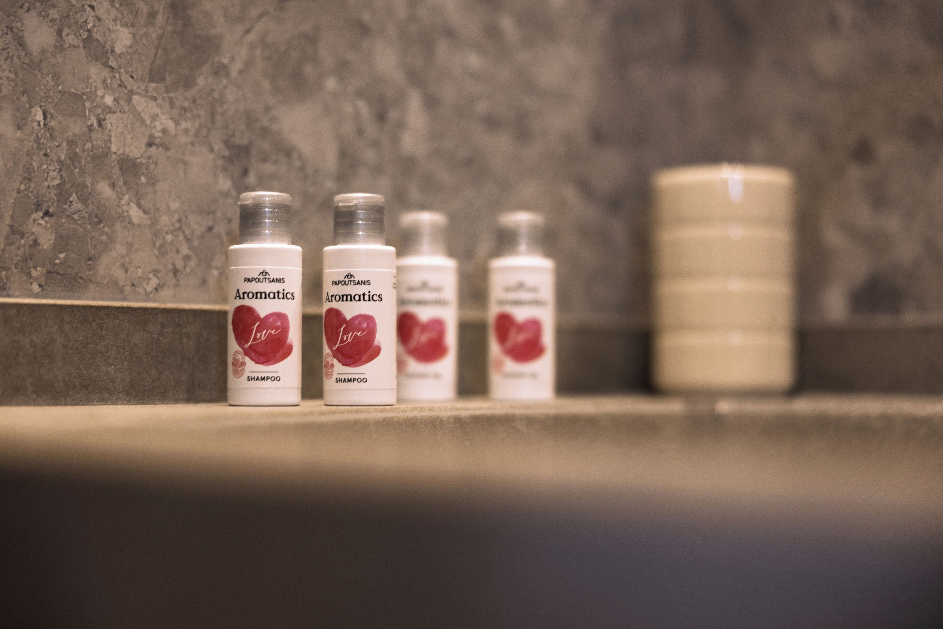 Four bottles of shampoo on a bathroom counter.