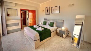 Ein Hotelzimmer mit Bett, Nachttischen, einem Spiegel und einer Tür.