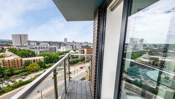 A high-rise building with a balcony overlooking a cityscape. - Yorksha Luxury Apartments | Leeds City | Balcony (West Yorkshire)