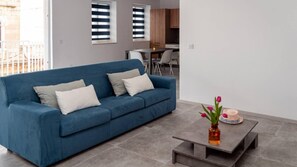 Relax in this stylish living room with a sofa, coffee table, and kitchen area.