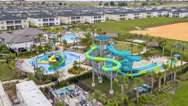 A resort with multiple swimming pools, a water park, and a large sandy area.