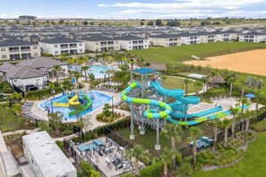 A resort with multiple swimming pools, a water park, and a large sandy area.