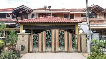 A gated residential property with a tiled roof, a garage, and a gated entrance.
