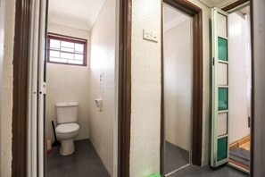 A narrow hallway with a toilet, a window, and a door leading to another room. - Kota Damansara ICozy Cove Homestay 10 Pax (Petaling Jaya)