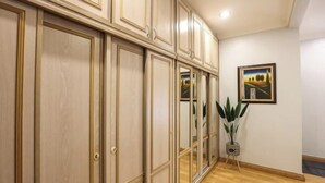 A hallway with wooden paneling, a potted plant, and a framed picture on the wall.