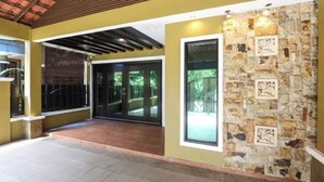 A hotel lobby with a stone wall, a glass door entrance, and a tiled floor.