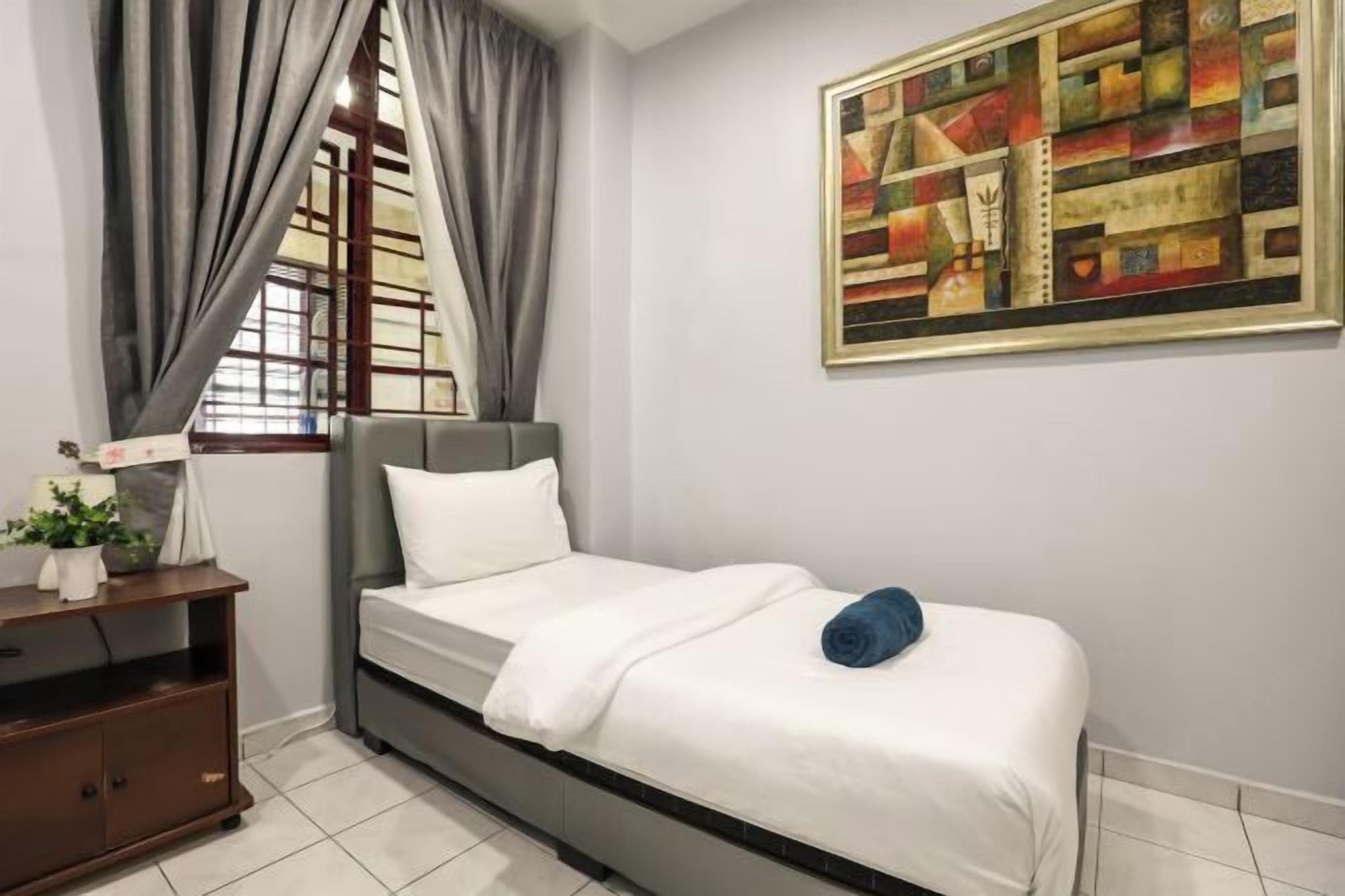 Un dormitorio con una cama, una mesita de noche, una ventana con cortinas y un cuadro en la pared.