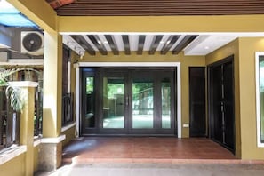 A building entrance with a covered walkway, a sliding glass door, and a black door. - Kota Damansara ICozy Cove Homestay 10 Pax (Petaling Jaya)