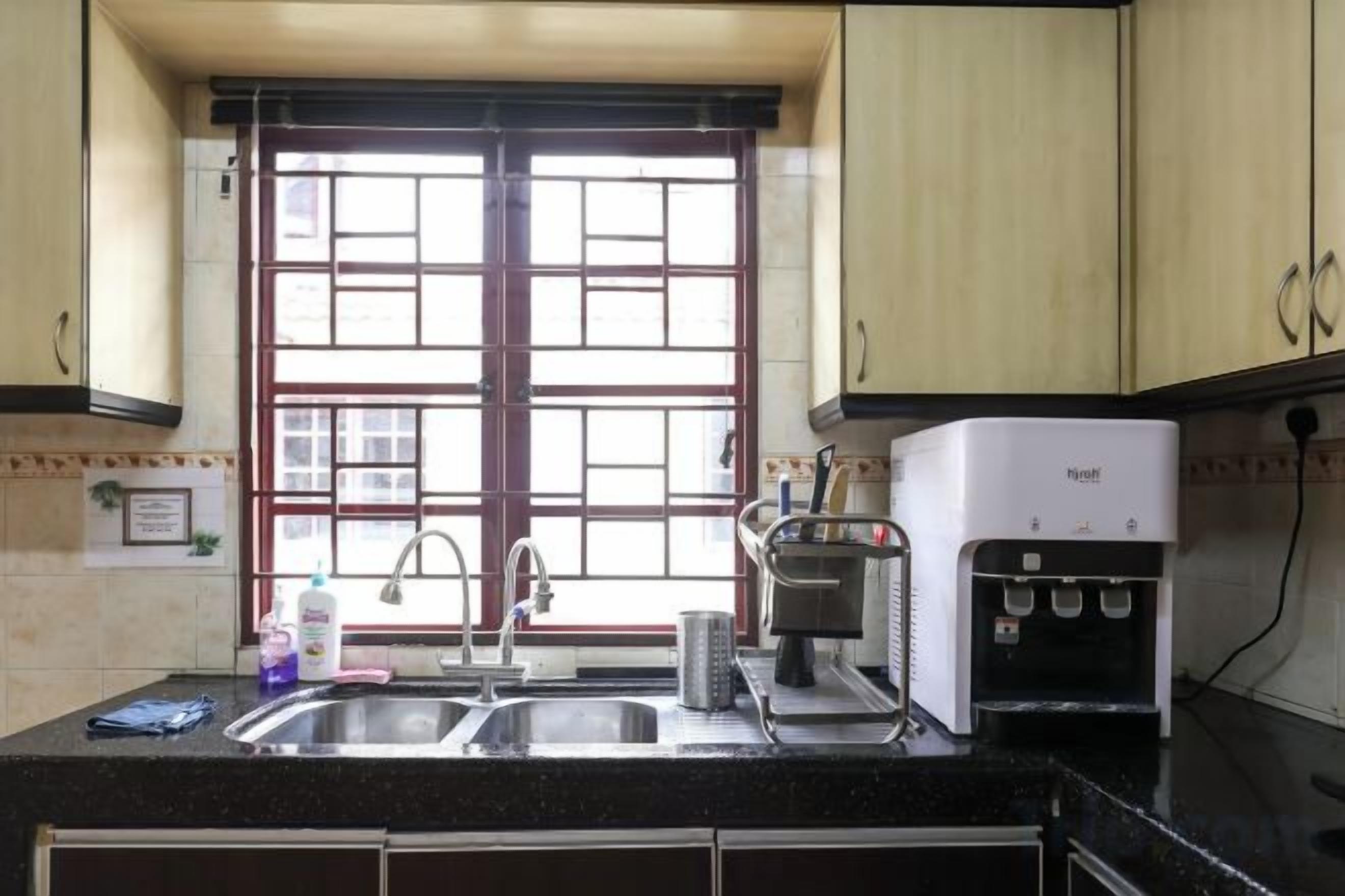 Una cocina con un lavamanos doble, una cafetera y un dispensador de agua.