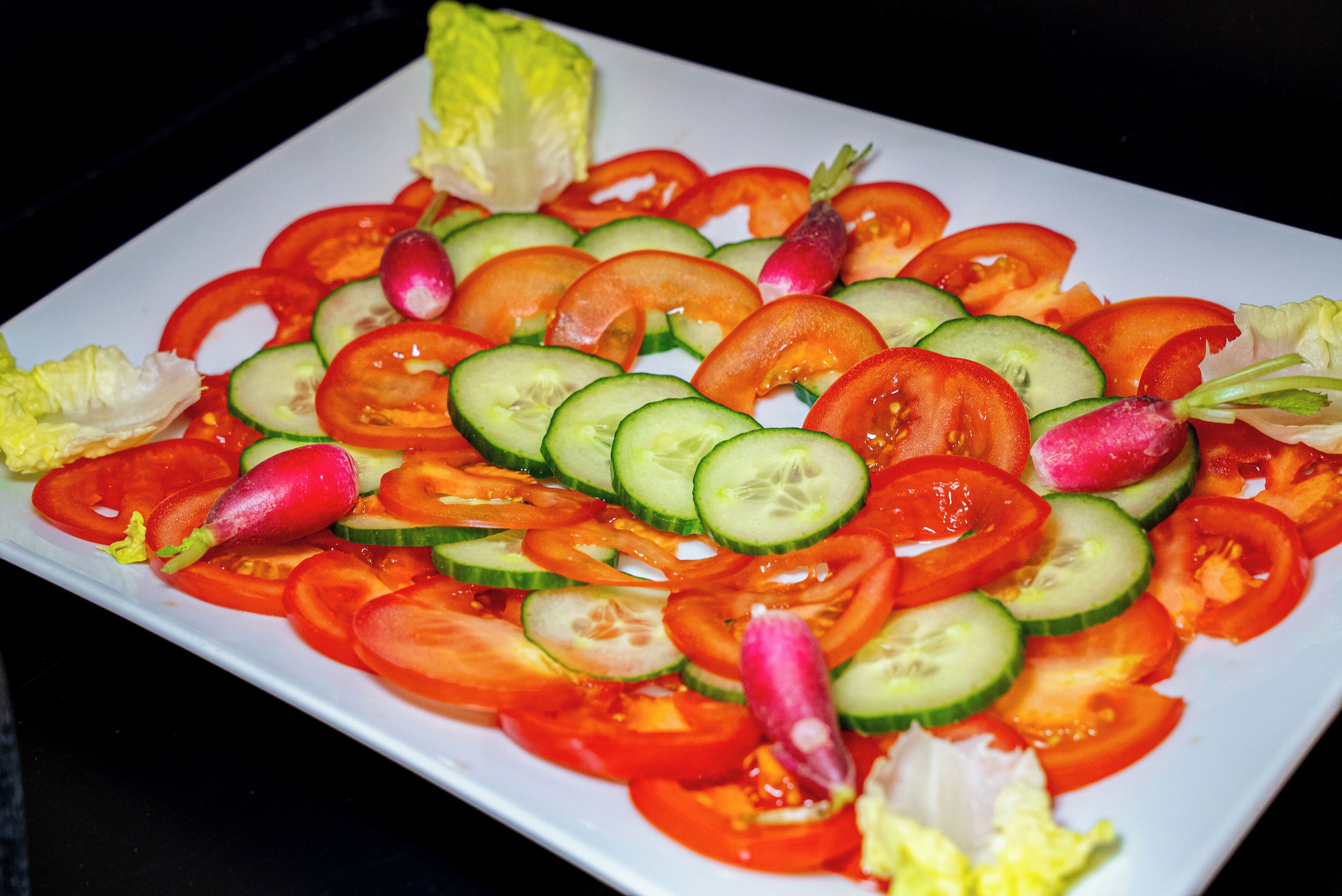 A white rectangular plate with a colorful vegetable salad.