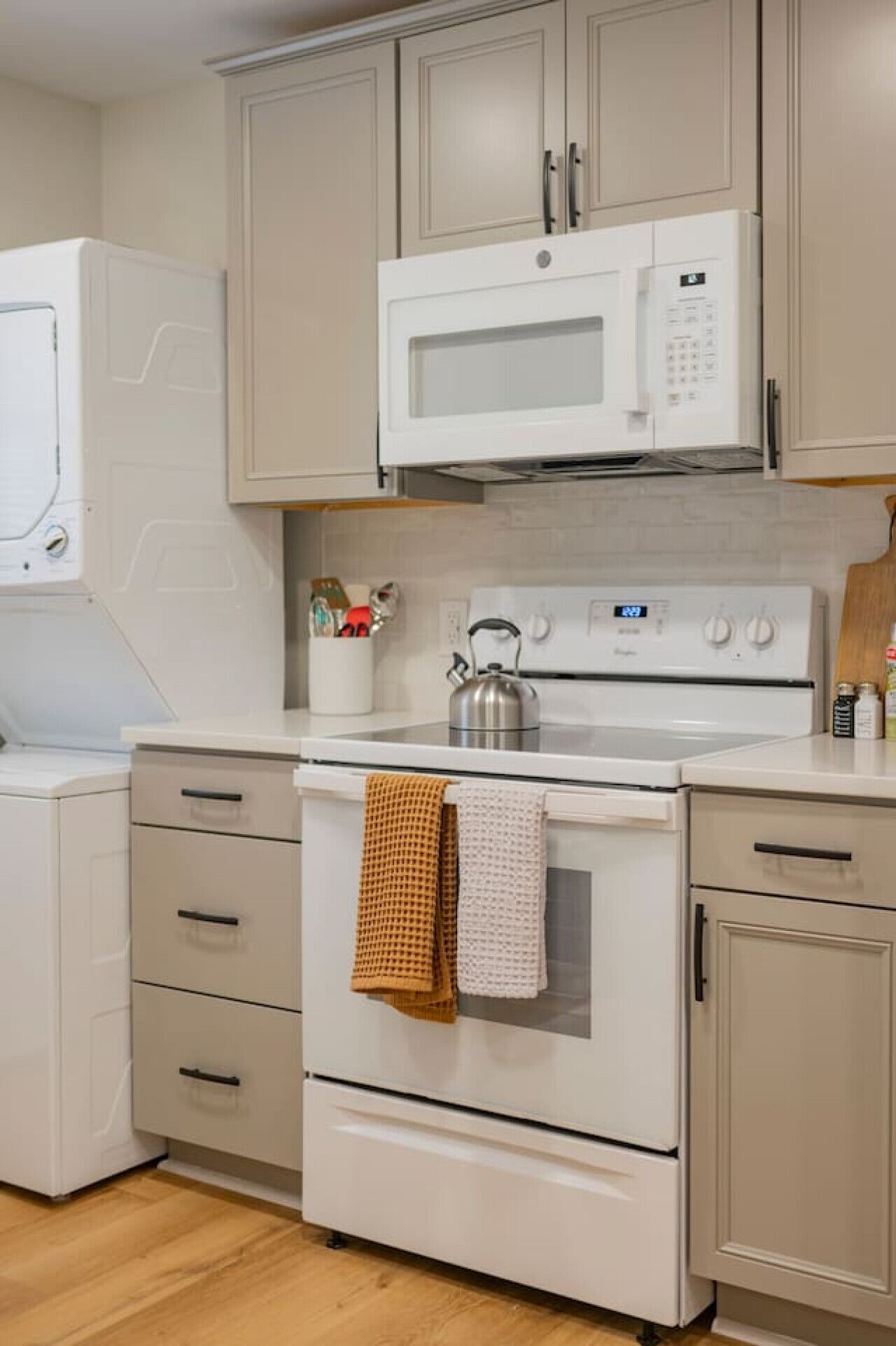 Une cuisine équipée d’un four à micro-ondes, d’une cuisinière et d’un four traditionnel. Elle comprend également des placards et un plan de travail.