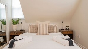 A bedroom with a large bed, two bedside tables, a mirror, and a window with blinds. - *Whole House* | 4-BR Home | 2 Kitchens + Free WiFi (Lynchburg)