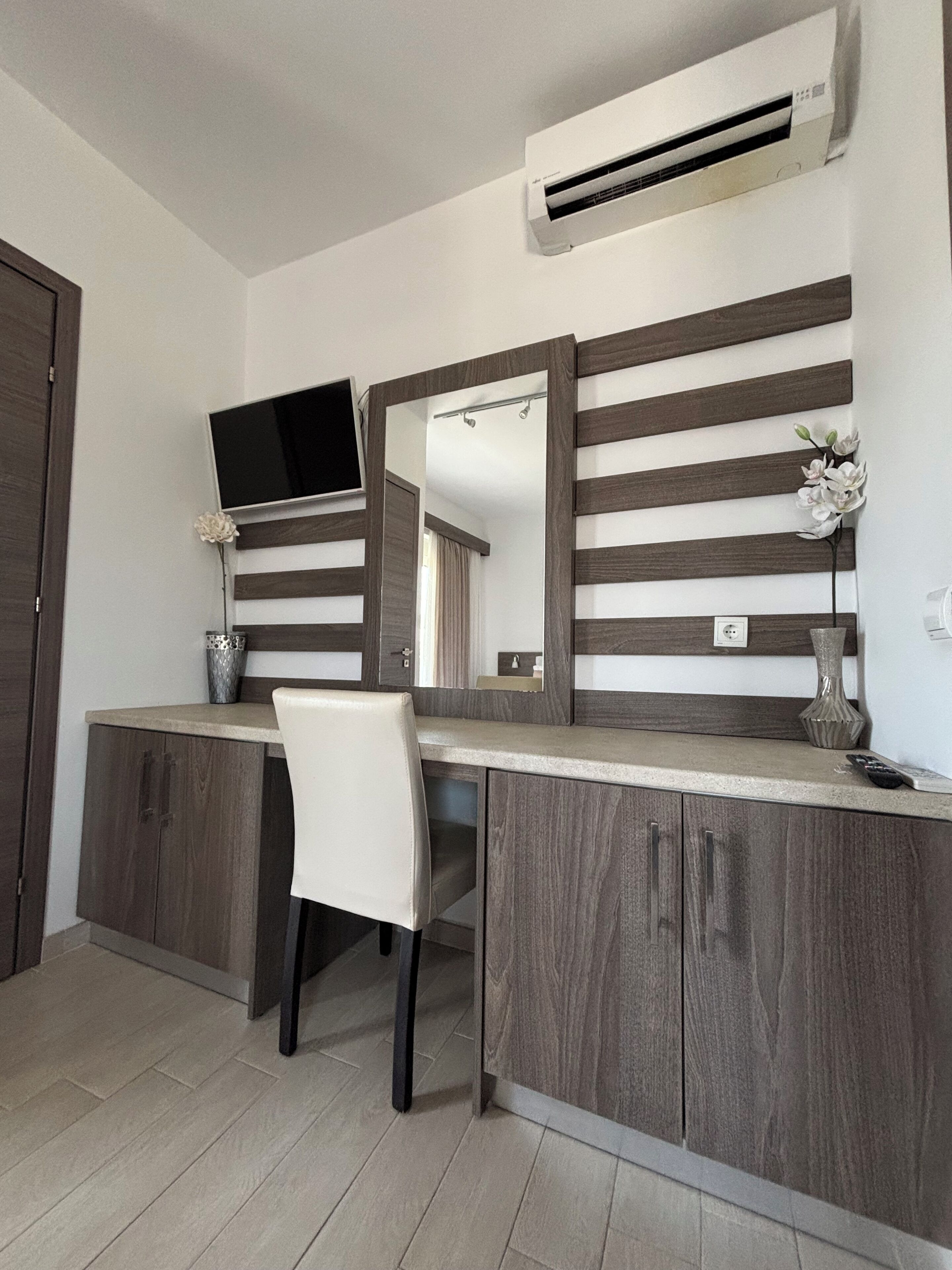 A modern kitchen with a built-in stove, a large mirror, and a flat-screen TV.