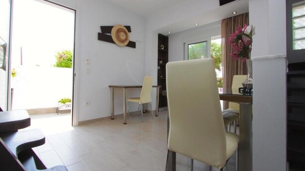 Ein moderner Essbereich mit Tisch und Stühlen, einer Wanddekoration und Blick ins Freie.