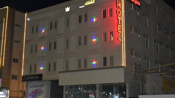 A hotel with a prominent 'HOTEL' sign, multiple windows, and a crown symbol above the entrance. - Al Taj Towers Hotel Apartments (Nejran)