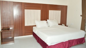 Un dormitorio con una cama grande, cabecera de madera y una mesita de noche.