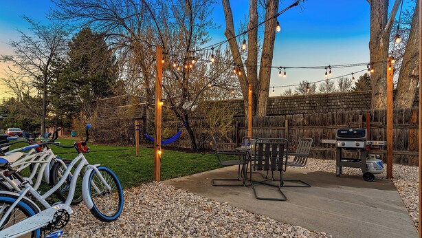 Un espace extérieur aménagé avec un barbecue, du matériel d’exercice et des vélos.