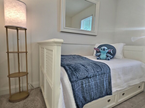 A bedroom with a white bed, a blue blanket, a floor lamp, and a mirror on the wall. - 3 BATHs, Immaculate, 86" TV, Huge+New+CLEAN! 4|3|3 (Palm Coast)
