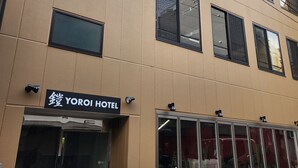 Un edificio con un letrero que dice "YOROI HOTEL" y una entrada de vidrio.
