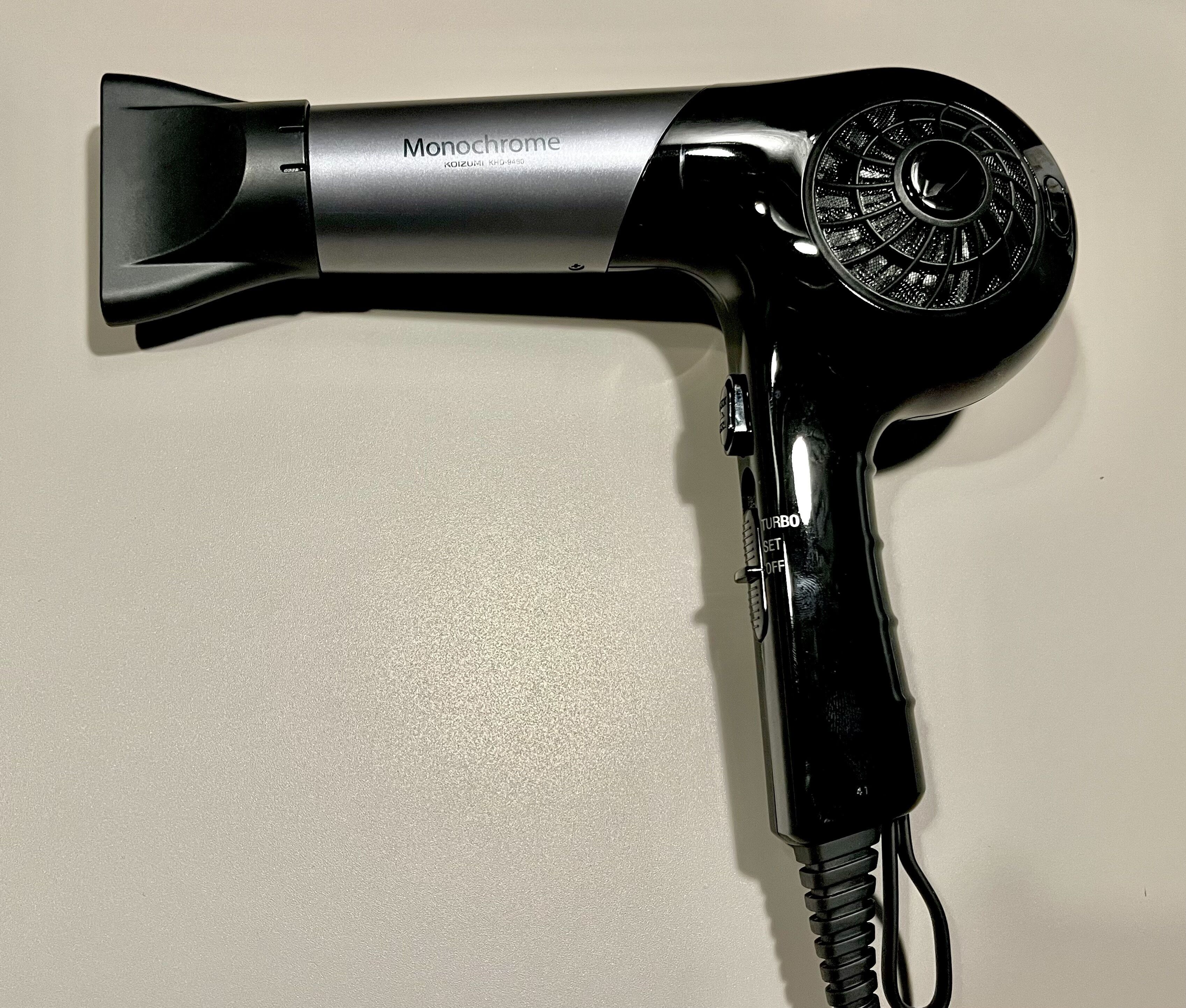 A hair dryer with a metallic body and a black handle, labeled 'Monochrome' and 'Turbo' on the side.