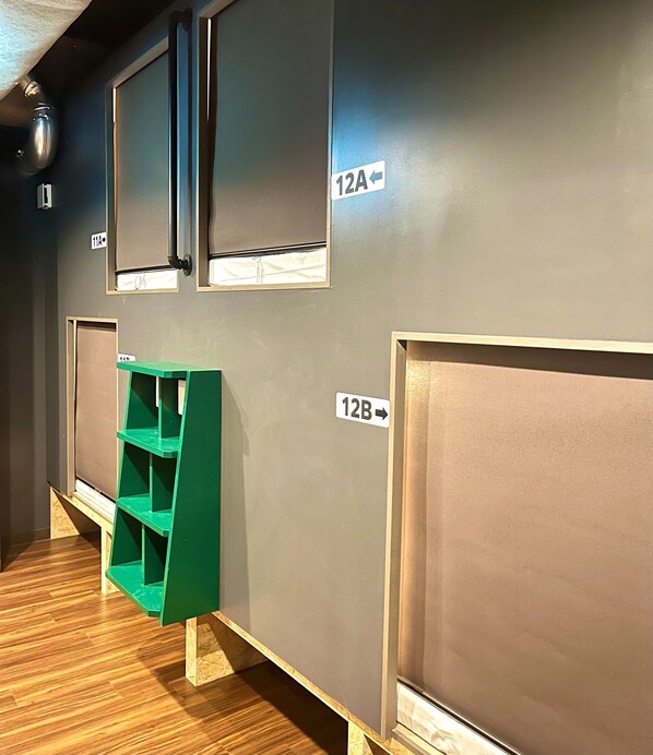 A hallway with numbered doors, a green storage unit, and a wooden floor. - Yoroi Asakusa Hotel (Tokyo)