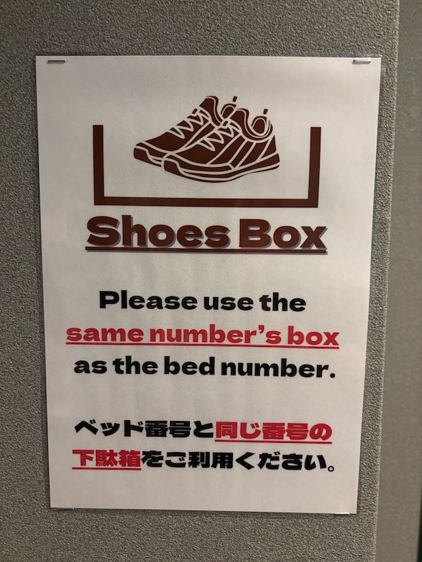 A sign with a shoe icon and text indicating a Shoes Box and instructions to use the same number as the bed number. - Yoroi Asakusa Hotel (Tokyo)