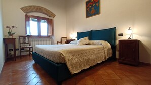 A bedroom with a bed, a window, a radiator, a chair, a table, and a lamp. - A few km from Siena Dietro le Mura vacation home in Colle Val d'Elsa (Colle di Val d'Elsa)