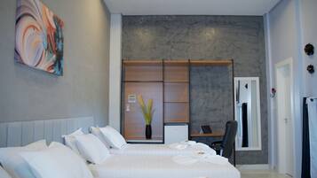 A modern hotel room with a large bed, a desk, and a wardrobe.