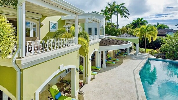 A large, two-story house with a pool, outdoor seating, and a covered patio area. - Celebration Villa with Private Pool & Sunset Views (Mount Standfast)