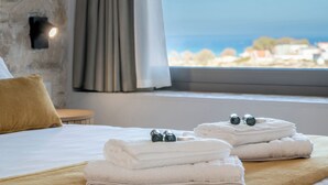 Habitación de hotel con cama, ventana y vistas a un pueblo, además de toallas sobre la cama.