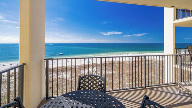 A balcony with a view of a beach and ocean.