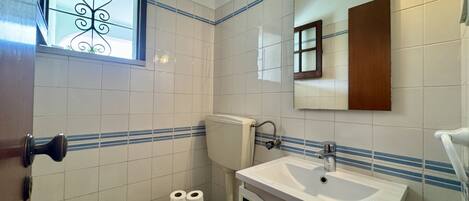 Ein Badezimmer mit Toilette, Waschbecken und Fenster.