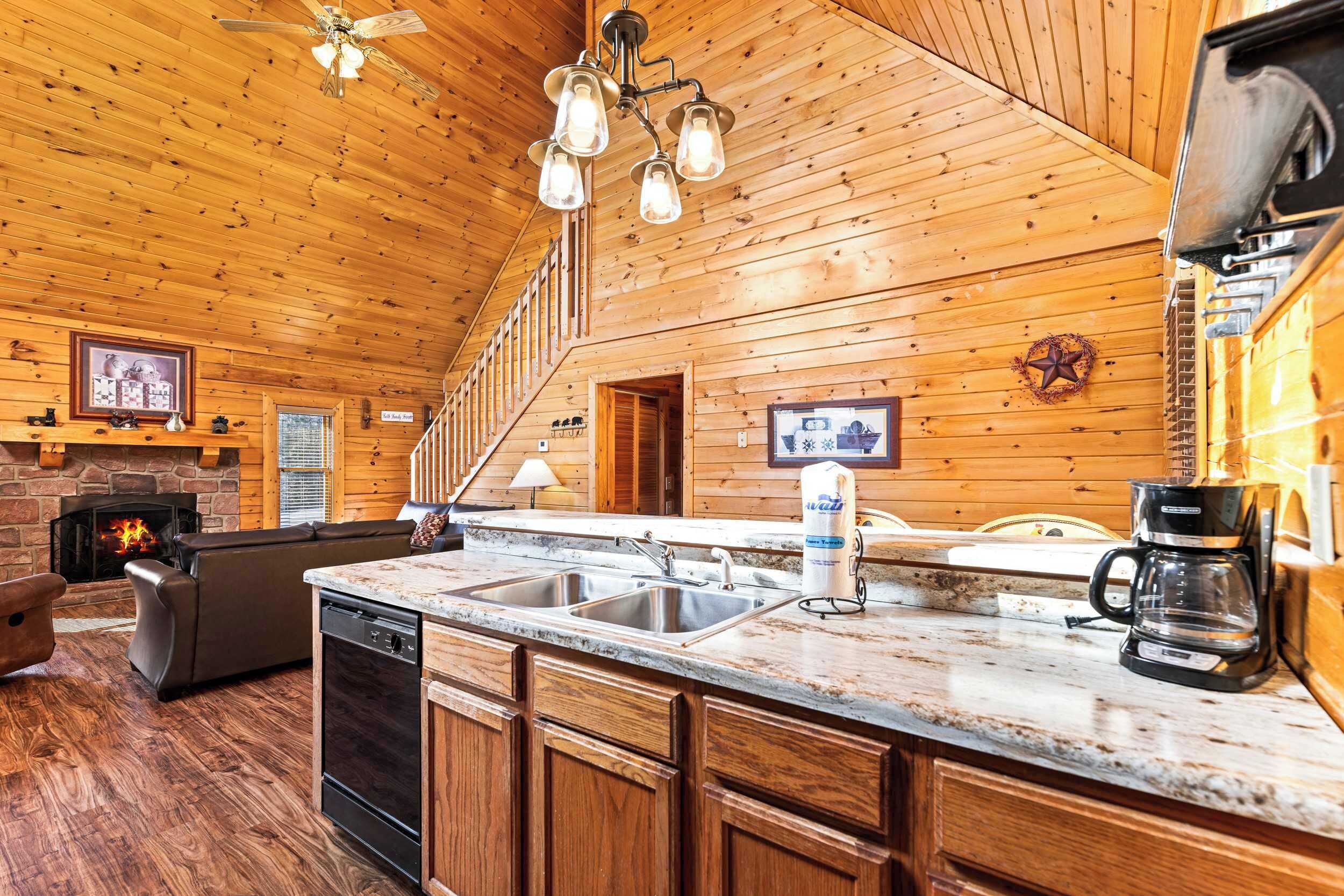 A wooden interior with a kitchen, dining area, and fireplace.