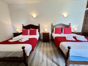 Two plush beds with matching headboards and footboards, each topped with a throw blanket and crisp linens.