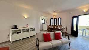 Un salon moderne avec un canapé, une table à manger et des meubles blancs.