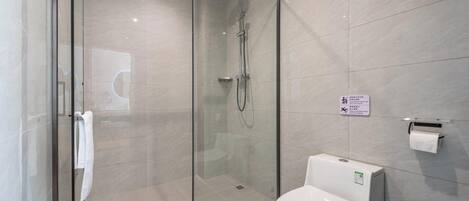 A modern bathroom with a glass-enclosed shower, a toilet, and a towel rack.