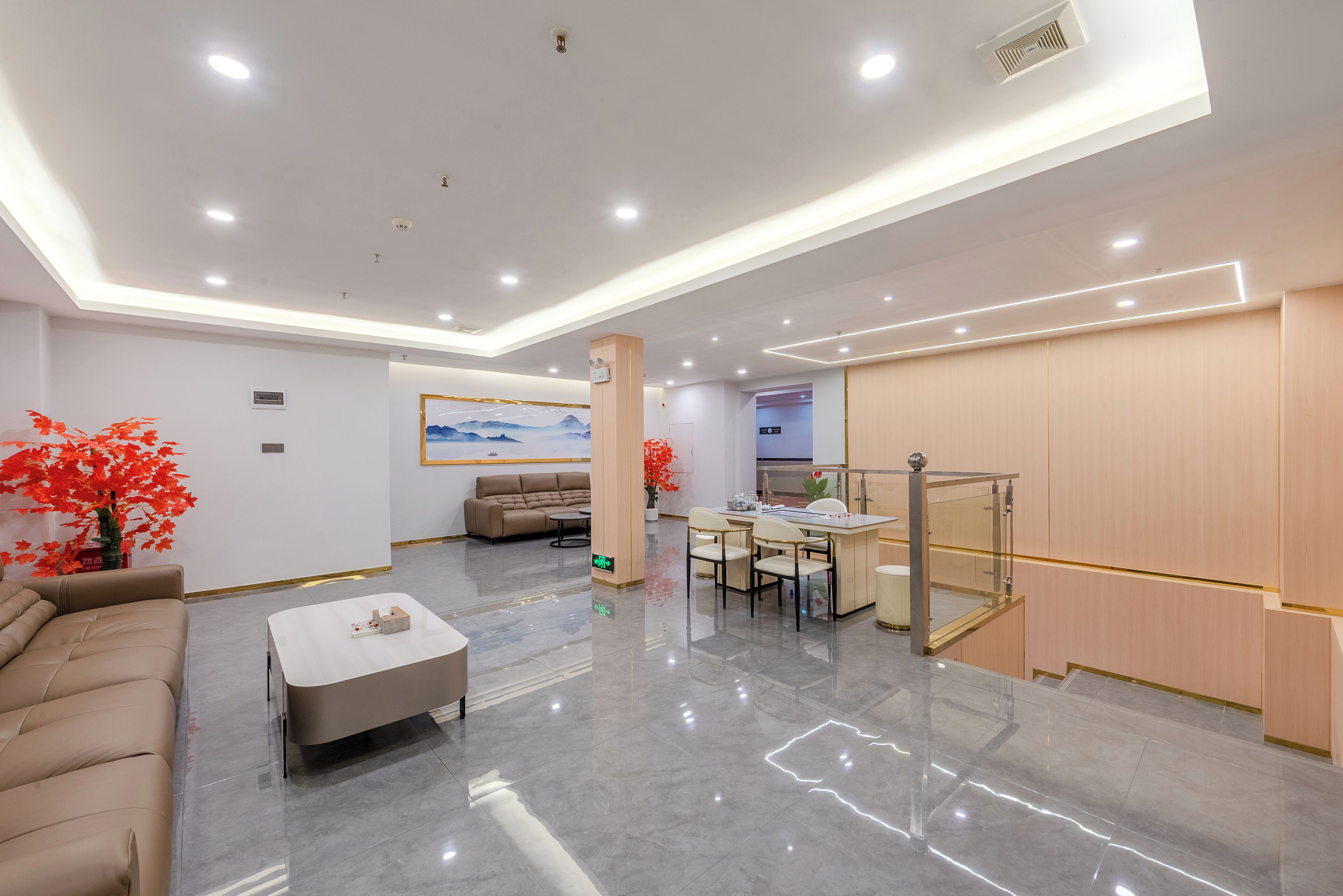 A modern hotel lobby with a seating area, a dining space, and a staircase.