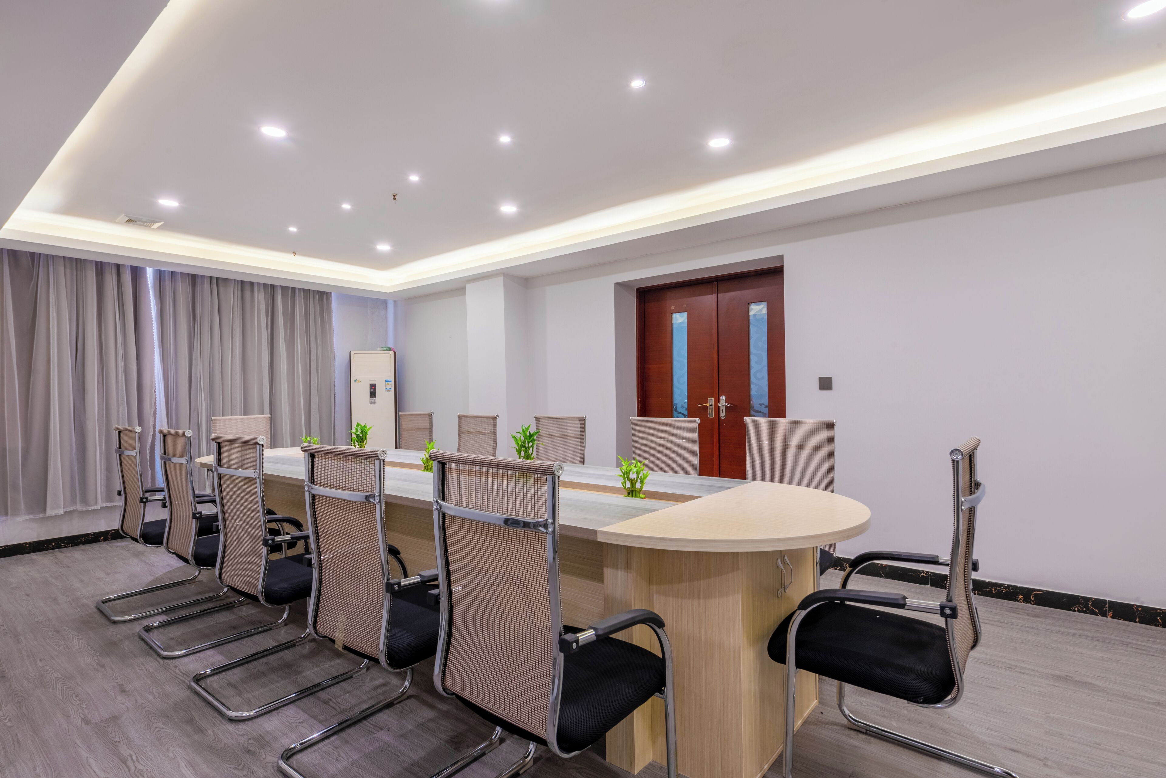 A conference room with a long table, six chairs, and a wooden cabinet.