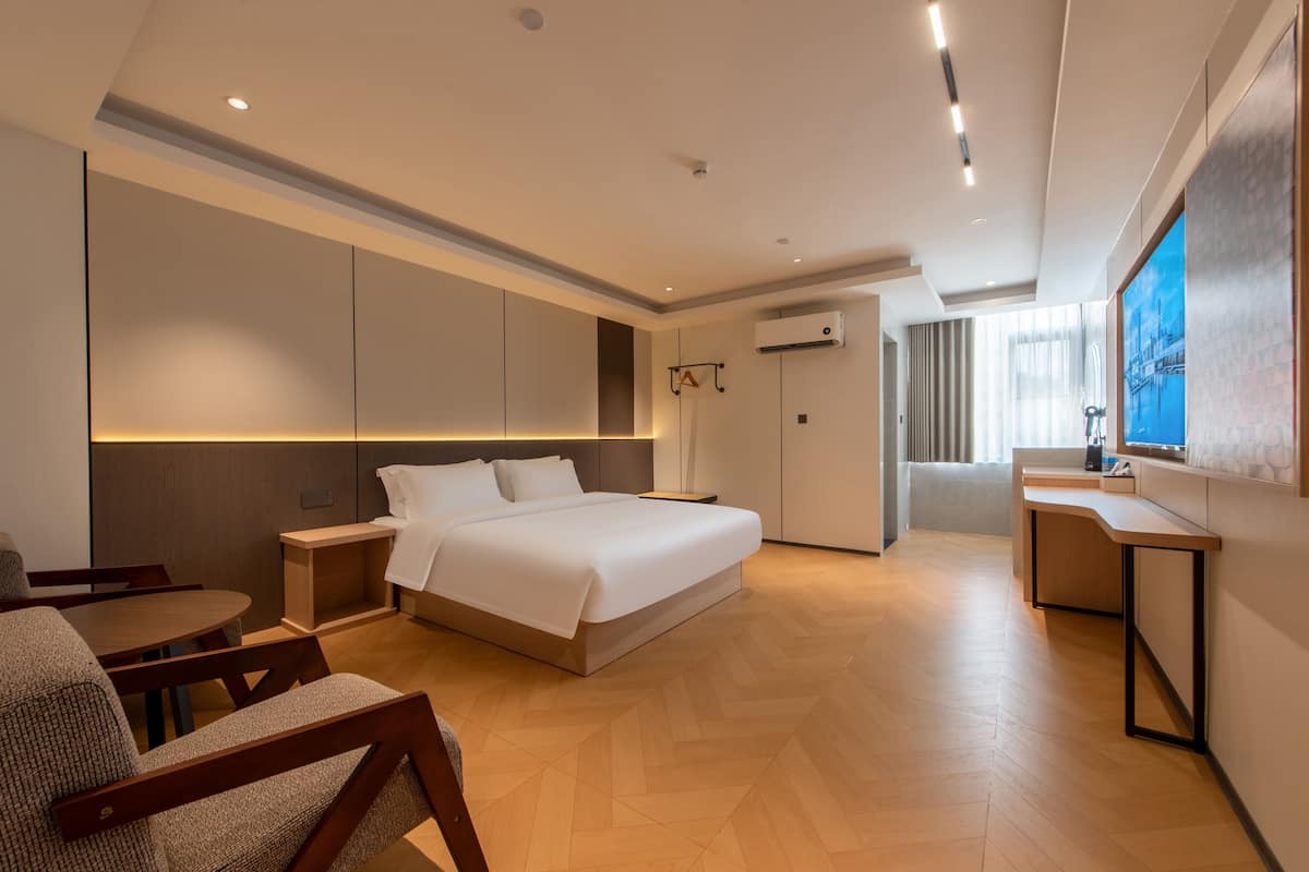 Een moderne hotelkamer met een groot bed, een bureau en een zithoek.