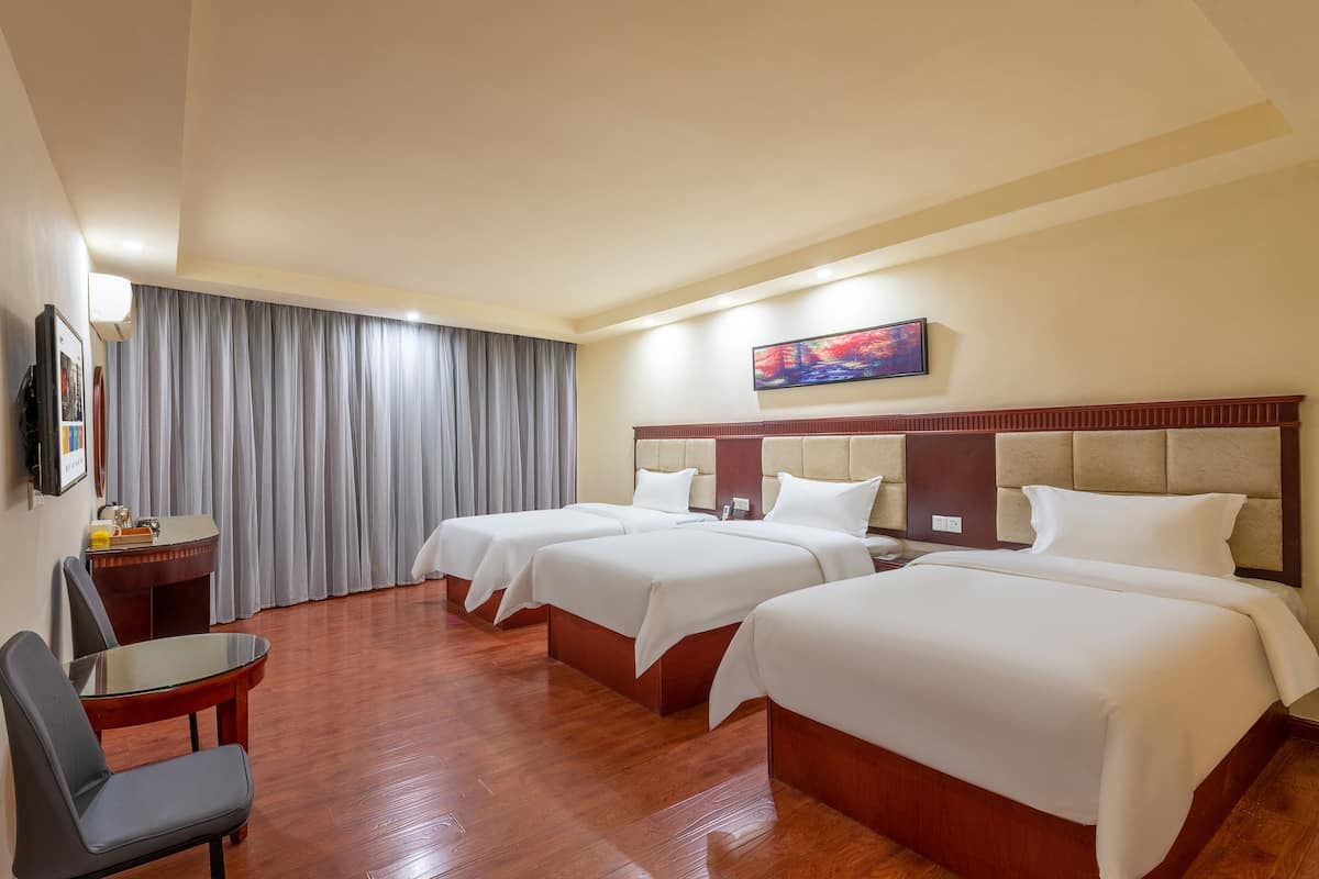 Een hotelkamer met twee bedden, een bureau en een stoel.