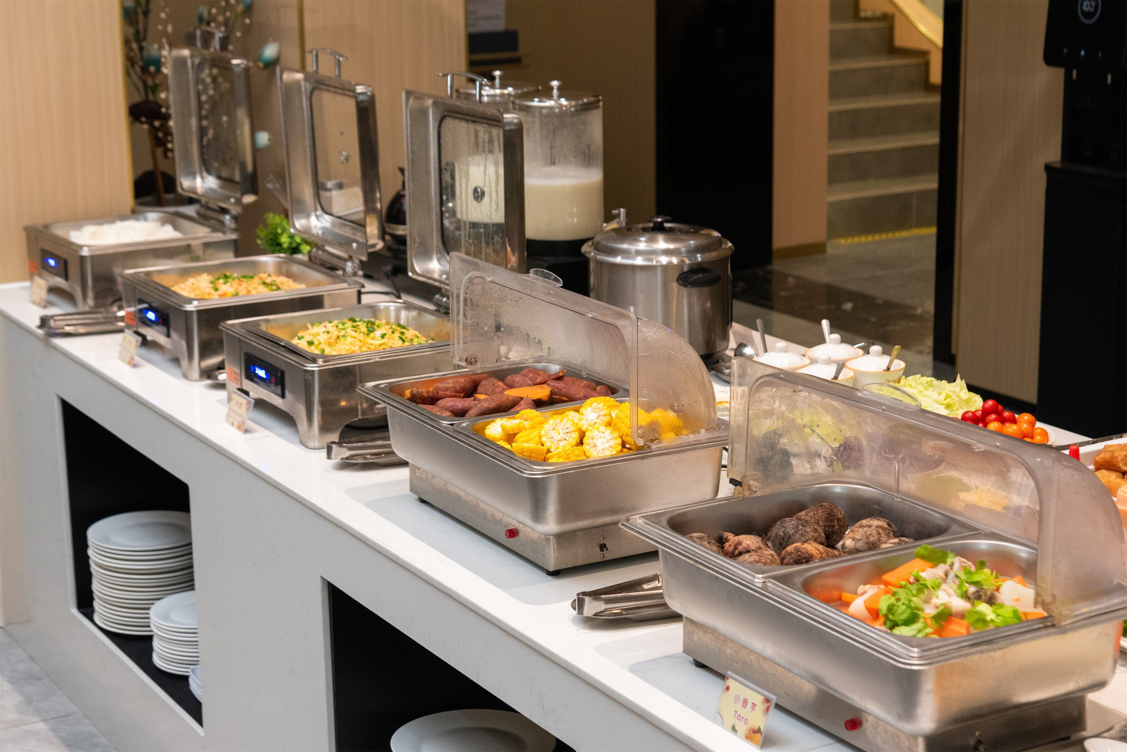 A buffet with various food options including meats, vegetables, and salads.