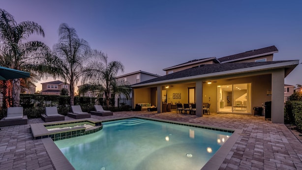 A swimming pool with lounge chairs and a covered patio area. - Fabulous Disney Vacation Home - 8bd - Private Pool w SPA - Near to Disney (Kissimmee)