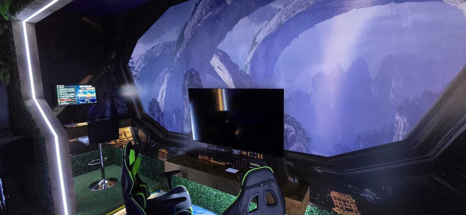 Una habitación futurista con una pantalla digital grande y una mesa metálica.