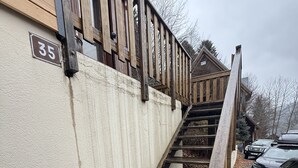 Una escalera de madera que lleva a un edificio con un letrero con el número 35.