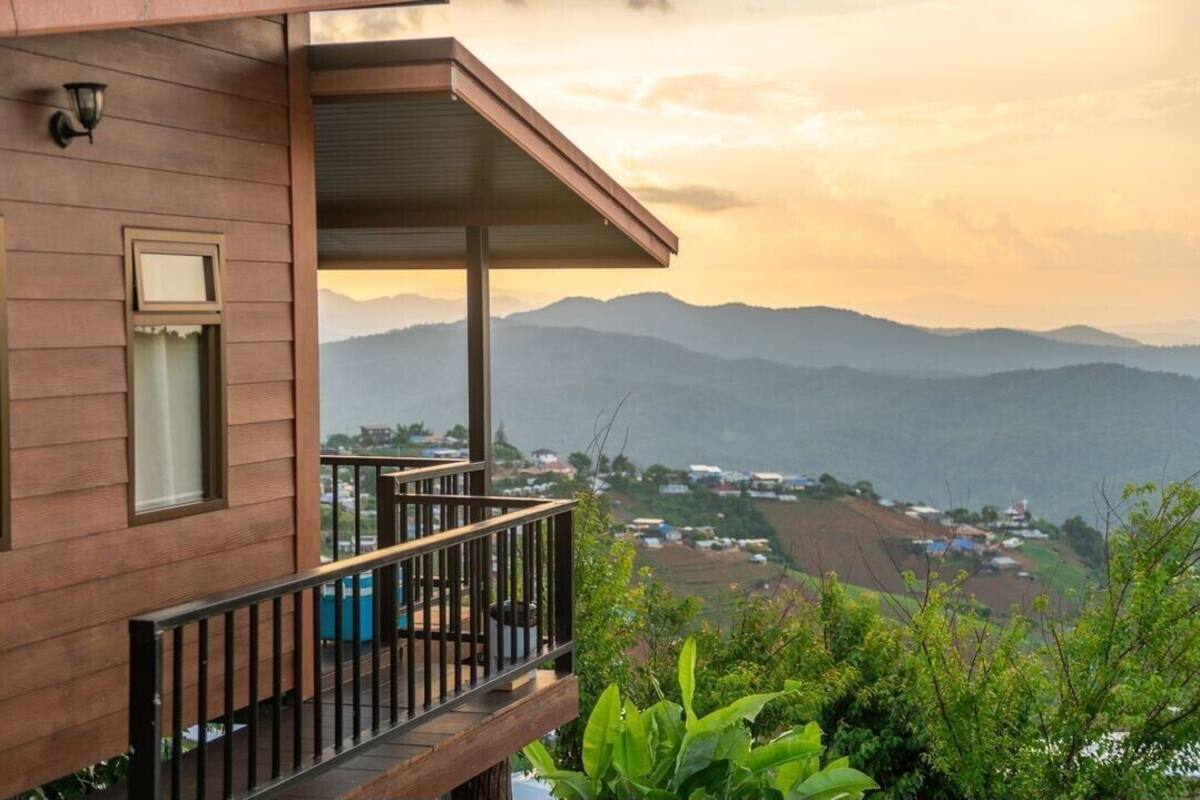 A wooden building with a balcony overlooking a mountainous landscape.