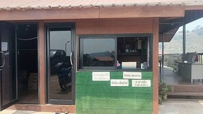 Standalone building with a glass door entrance and a motorcycle visible inside.